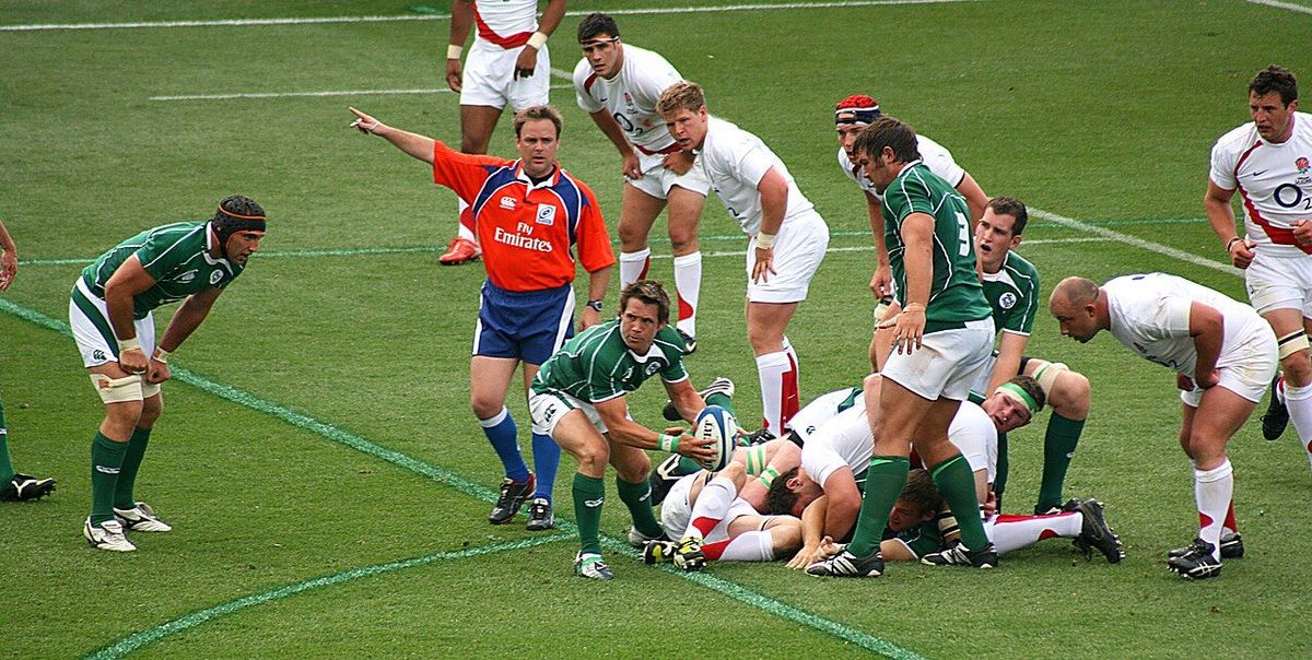 Rugby referee signalling offside during a match