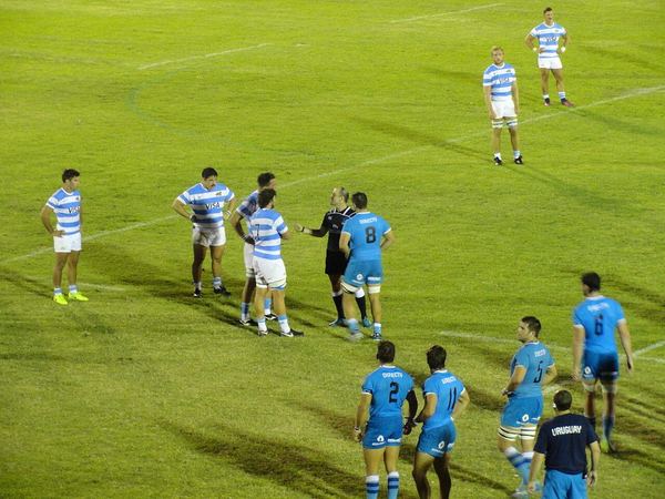 Rugby referee showing a yellow card to a player